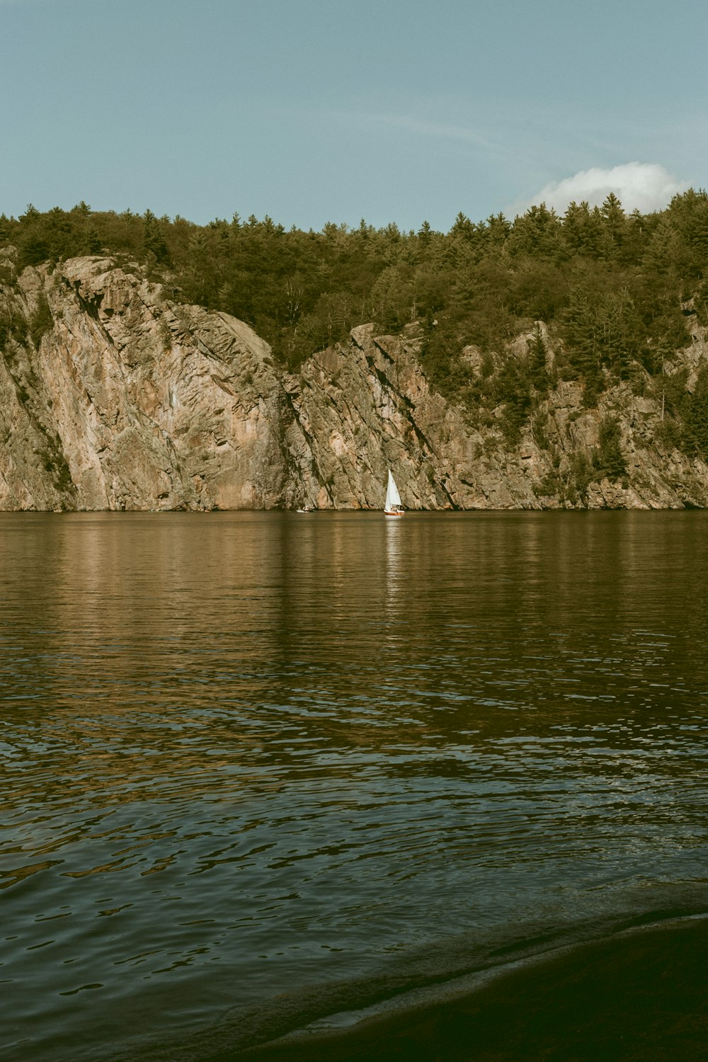 body of water near mountain during daytime