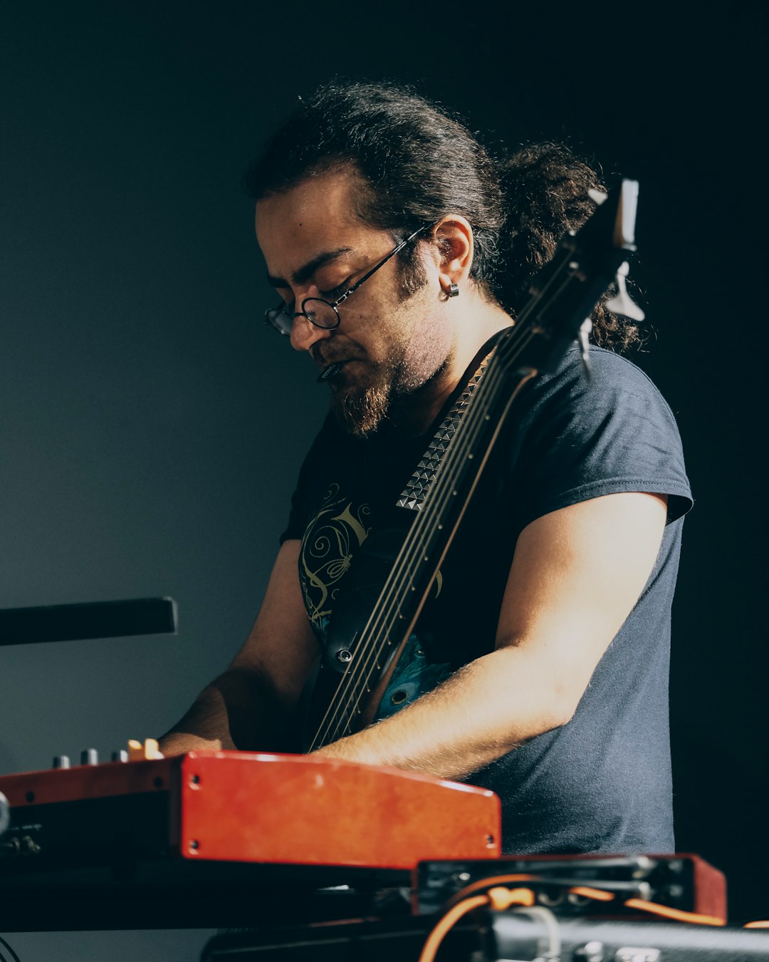 man in black crew neck t-shirt playing guitar