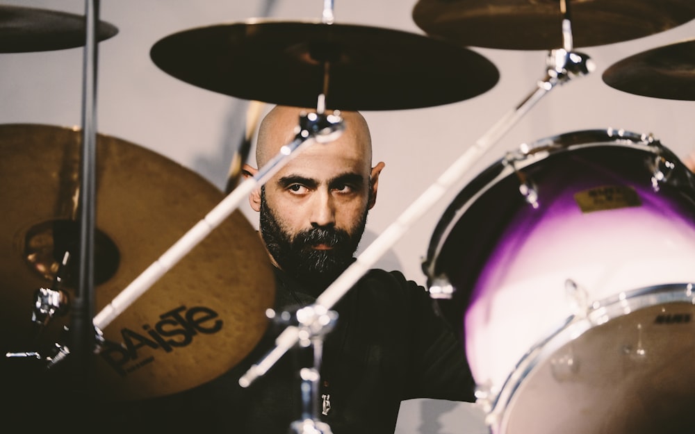 man in black shirt playing drum set