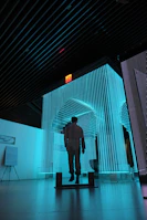 man in black jacket standing on blue lighted room