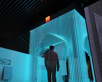 man in black jacket standing on blue lighted room