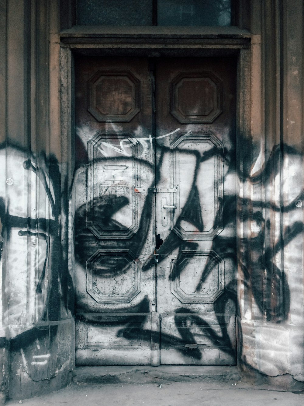 brown wooden door with graffiti