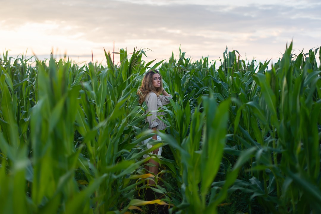 woman in white long sleeve shirt standing on green grass field during daytime