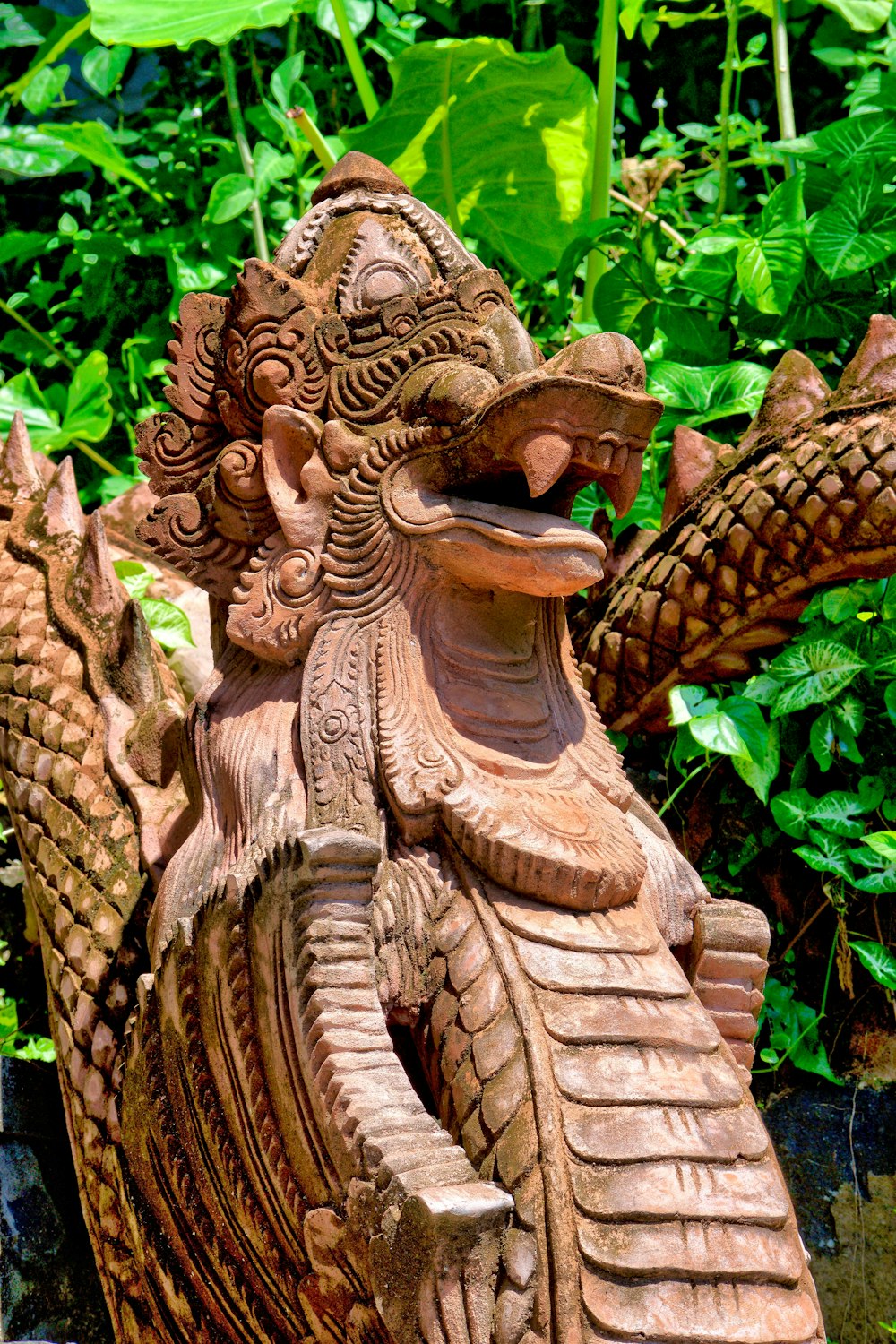 brown wooden angel statue near green leaves