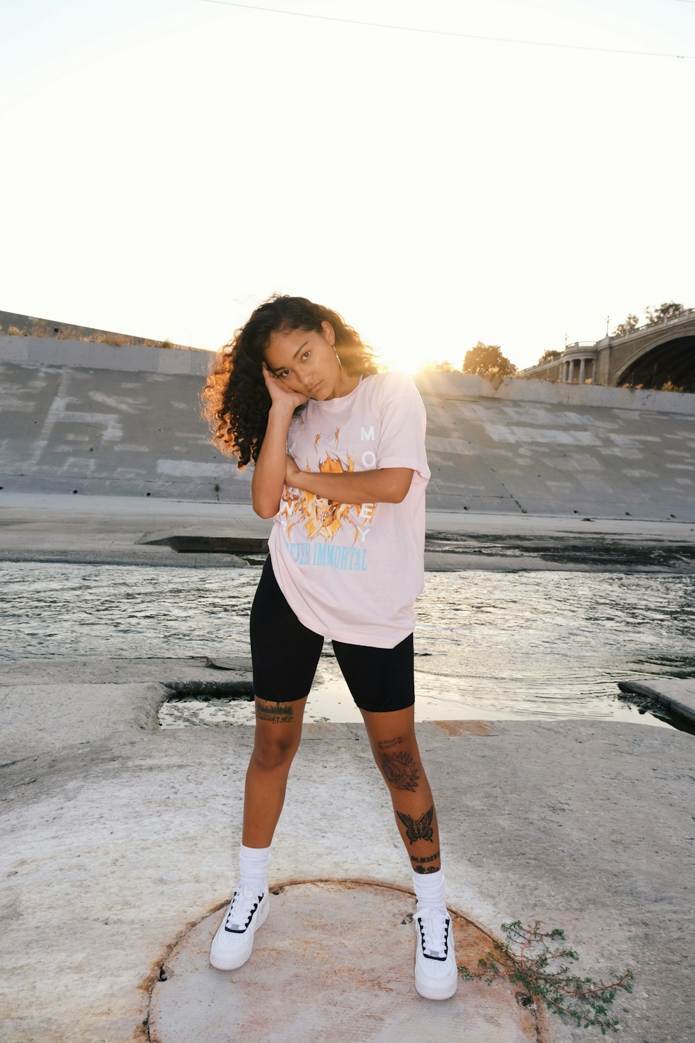 Mujer con camiseta rosa y pantalones cortos negros de pie en la playa durante el día