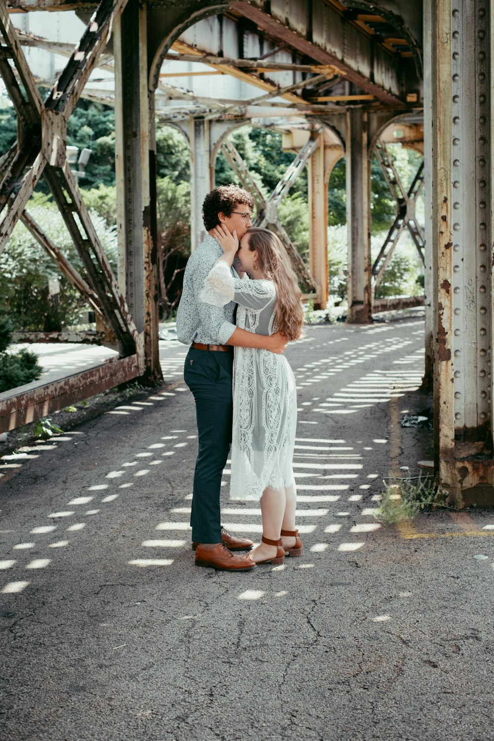 woman in white long sleeve shirt and blue denim skirt standing on gray concrete road during