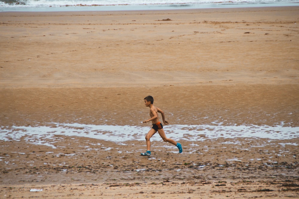 woman in black bikini walking on beach during daytime