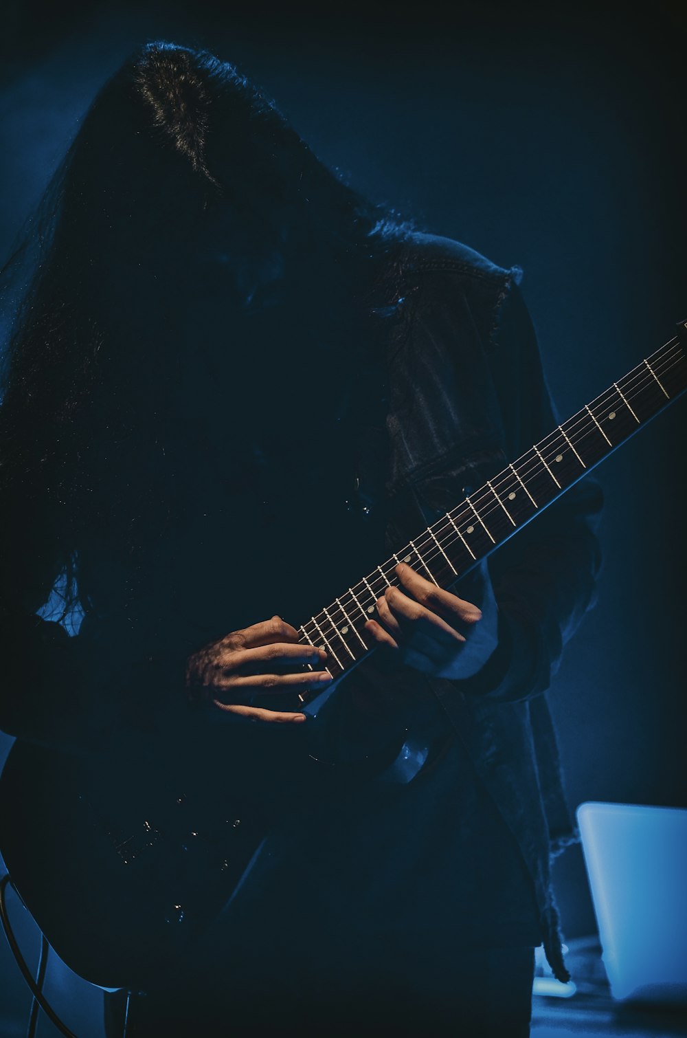 man playing guitar in dark room