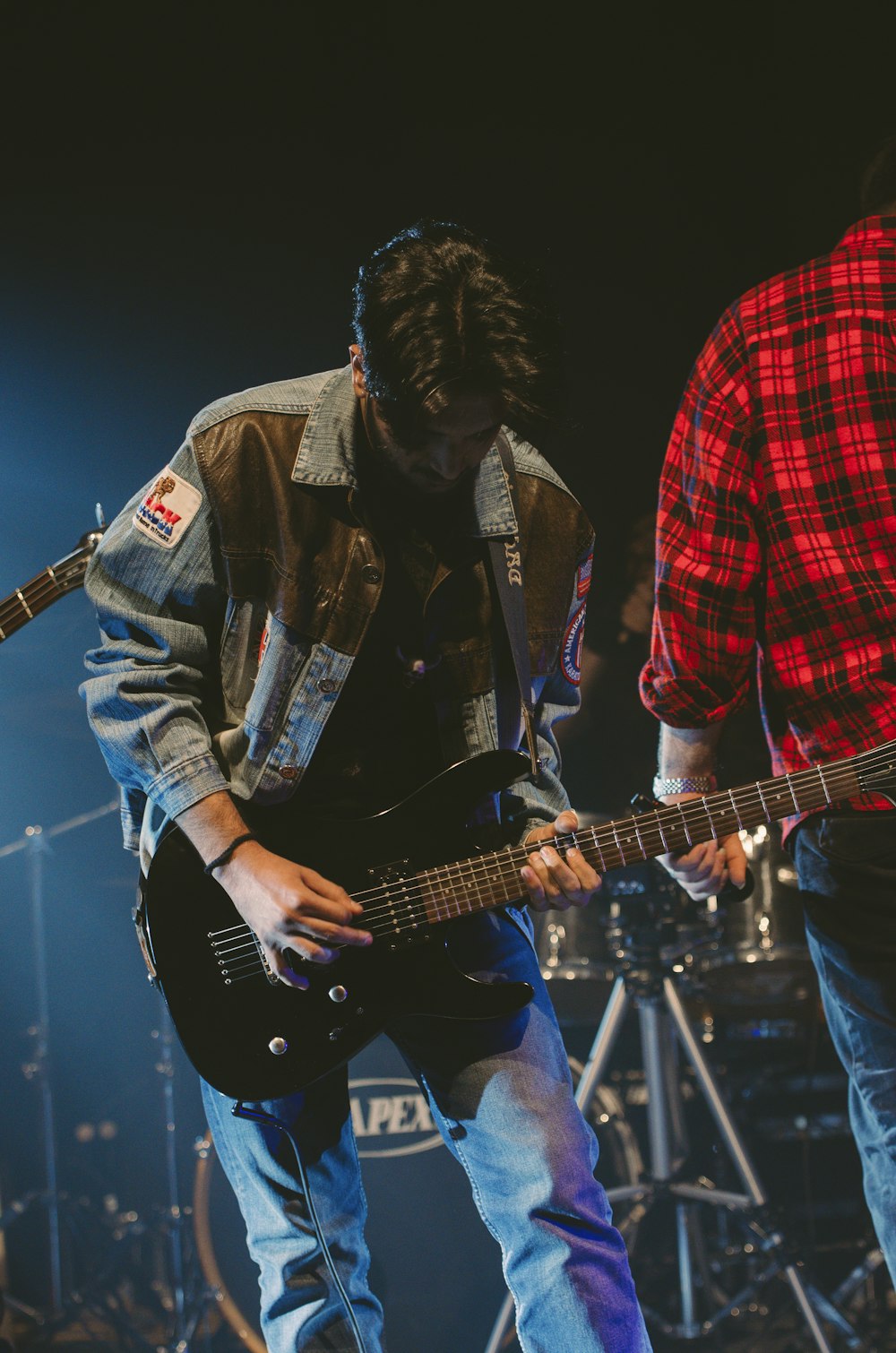 man in red and black plaid button up shirt playing electric guitar