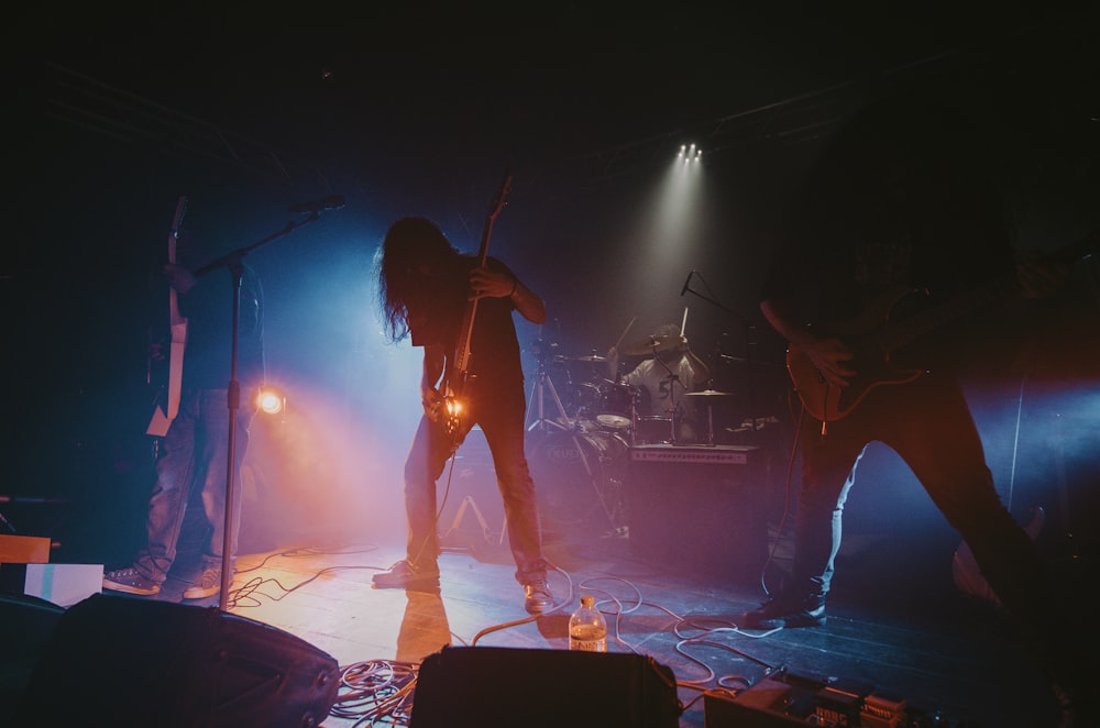 man in black shirt playing guitar on stage