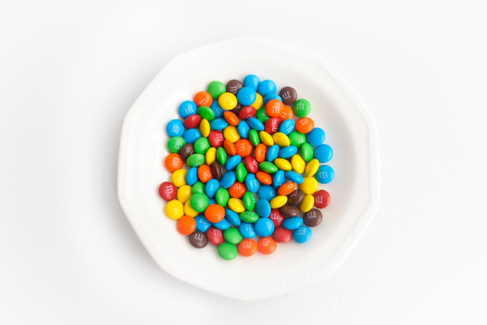 yellow green and red candies on white ceramic round plate