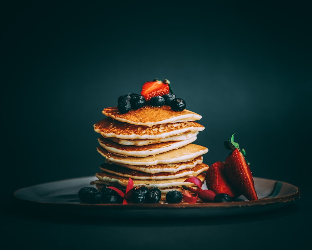 pancakes with strawberries and blueberries on top, This photo was taken by Sam Moghadam Khamseh in 2018.