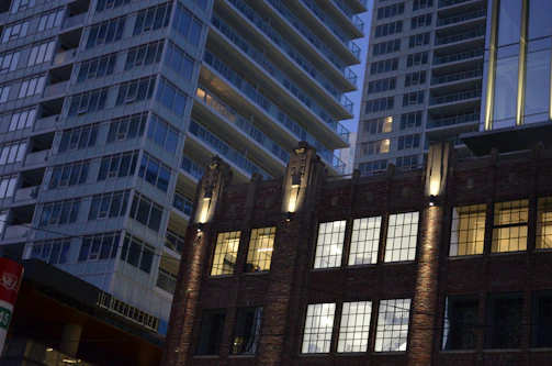 Evening cityscape highlighting modern structures with warm, inviting illumination.