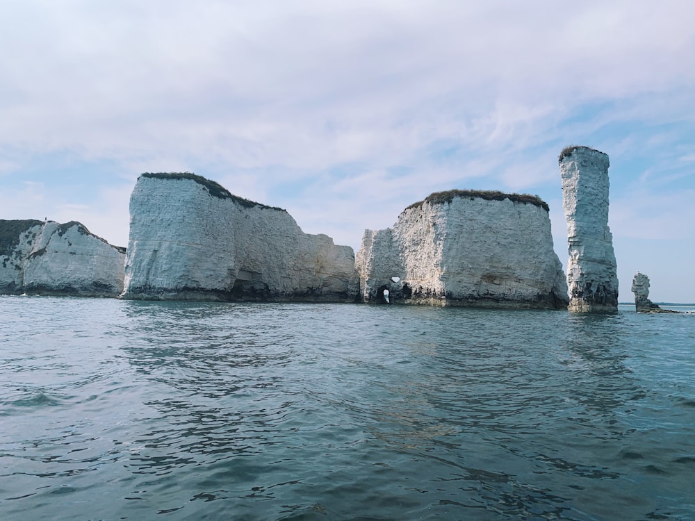 Formation rocheuse brune sur la mer sous les nuages blancs pendant la journée