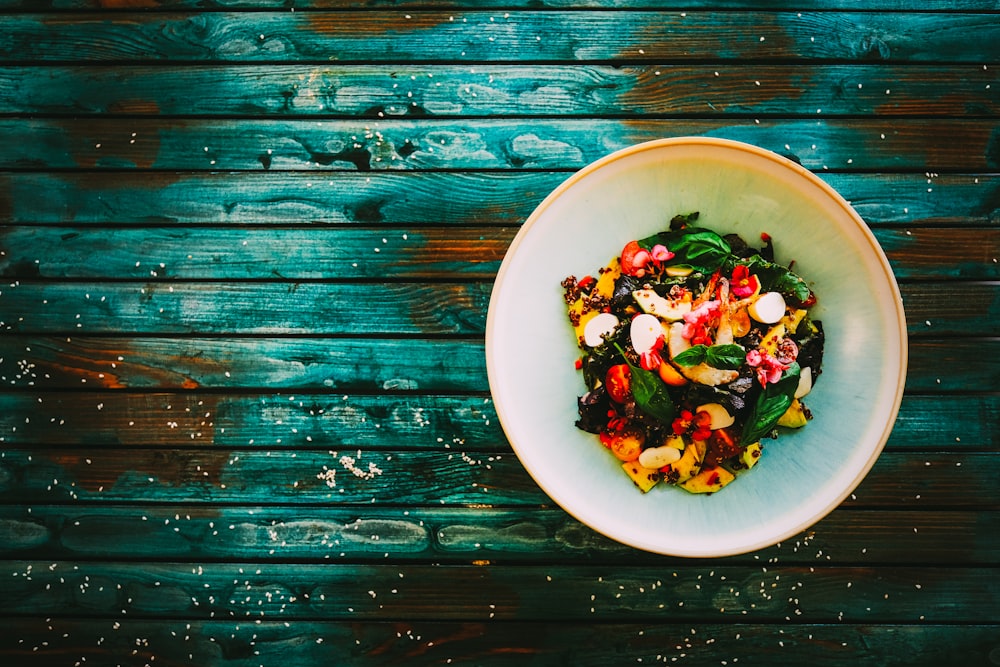 Ensalada de verduras en bol de cerámica blanca