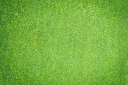 Aerial view of a large commercial artificial grass installation in progress with workers and machinery.