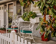 A charming front porch with a welcoming bench and potted plants, inviting you to imagine your new home.