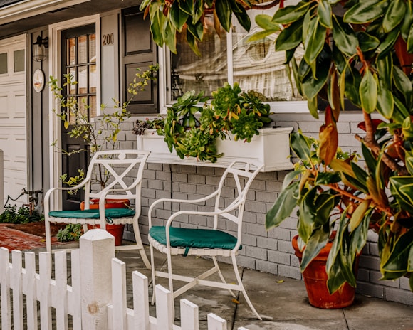 Charming front porch with potted plants and a welcoming bench.
