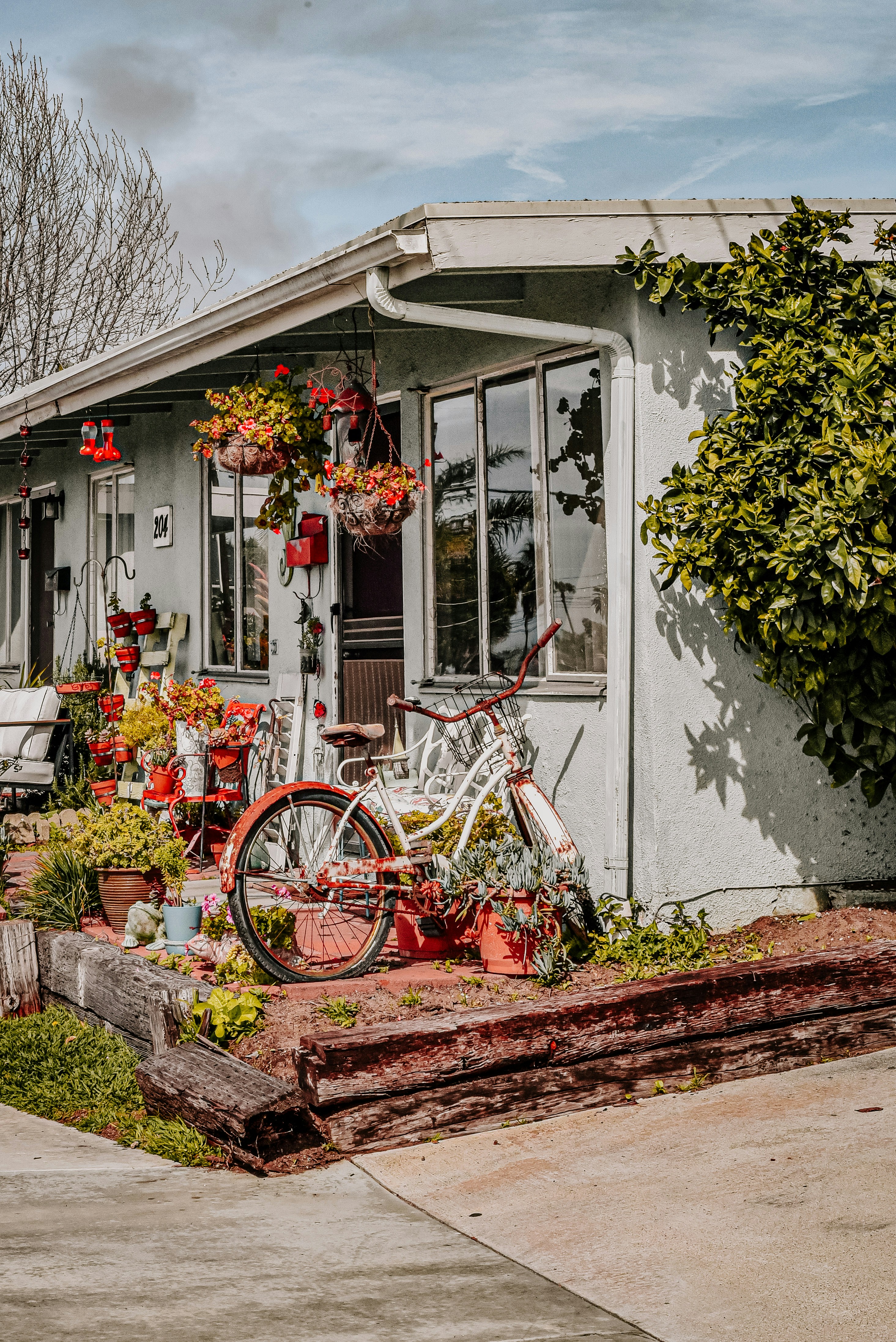 Vélo rouge garé à côté d’un bâtiment en béton blanc