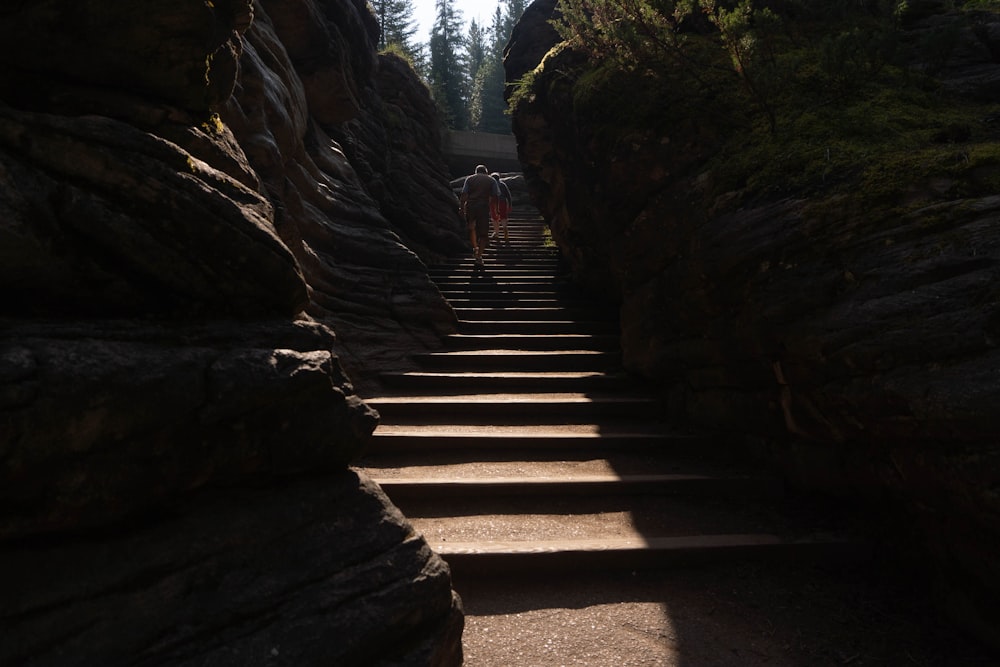people walking on stairs between rocky mountains during daytime