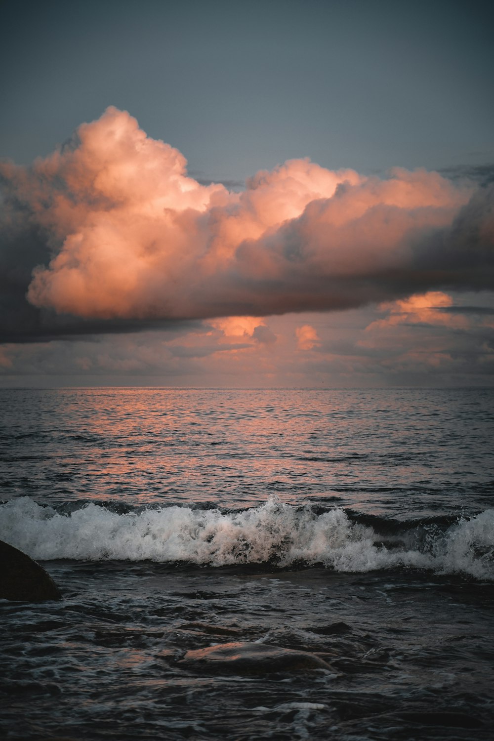 ondas do mar batendo na costa durante o pôr do sol