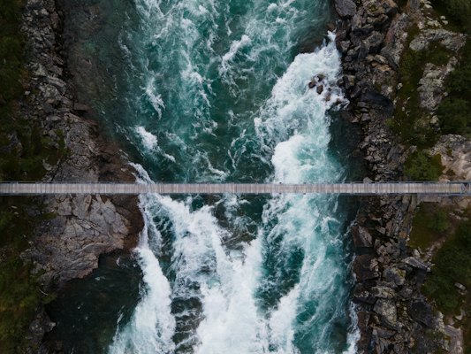 A footbridge over a rushing river in Sarek National Park — Jokkmokk, Sweden
