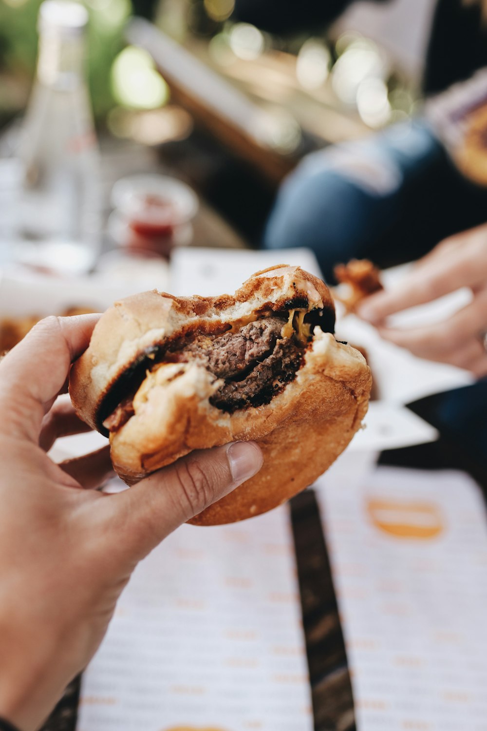 person holding burger with patty