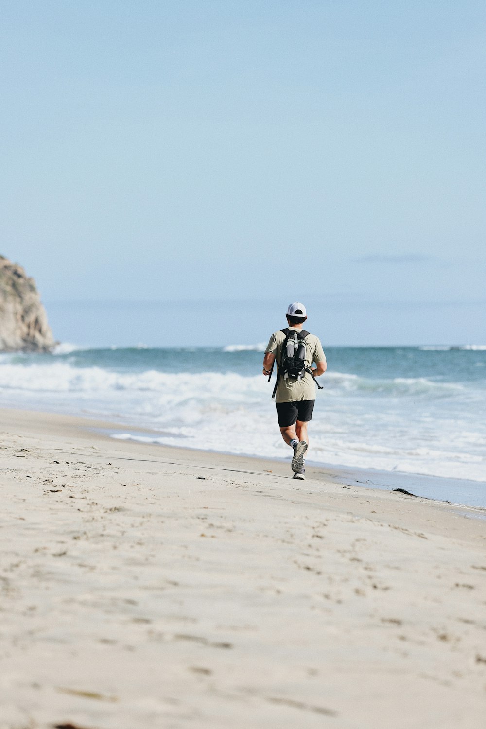 woman in black and white long sleeve shirt and blue denim shorts walking on beach during