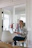 A warmly lit close-up of a happy woman working on a laptop in a modern office with subtle tech decor.