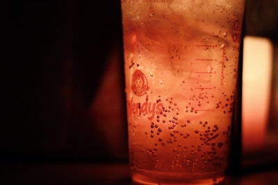Refreshing soda with ice cubes and a slice of lime, glowing under warm ambient light.