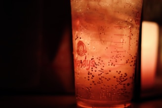 Refreshing soda with ice cubes and a slice of lime, glowing under warm ambient light.