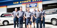 Two brothers in work uniforms smiling confidently in front of their Fraterfix service van.