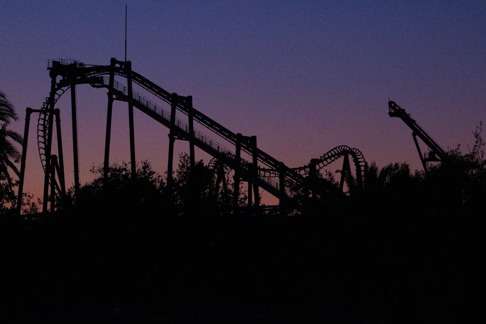 silhouette of bridge during night time