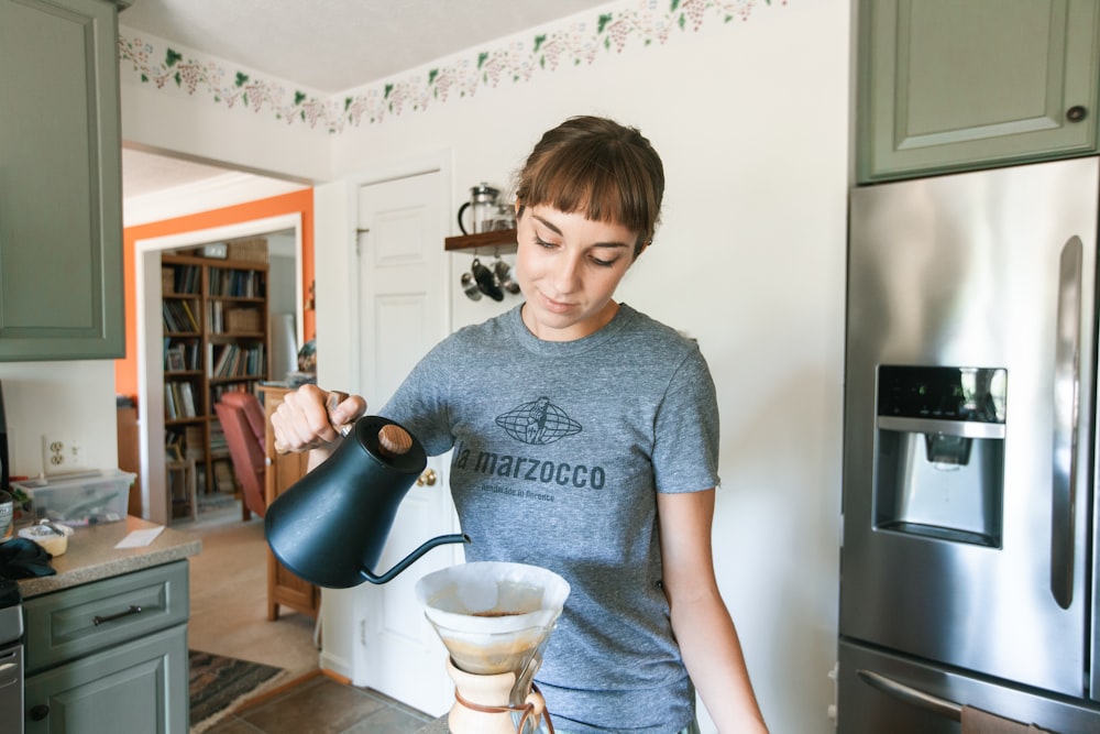 boy in gray crew neck t-shirt holding blue ceramic mug