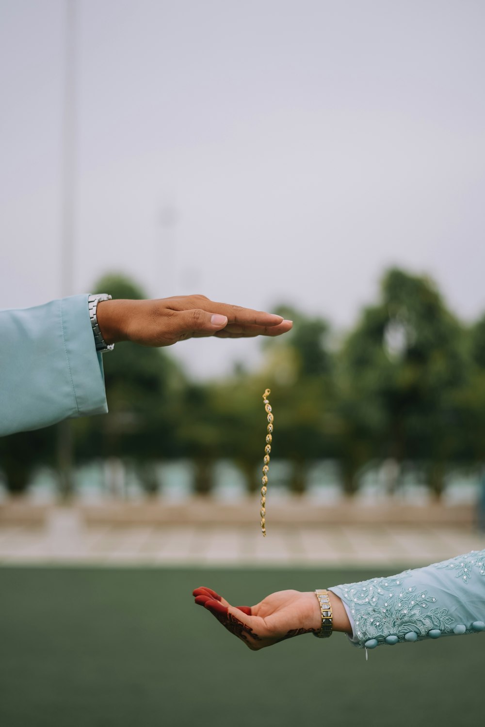 person holding brown and white beaded necklace