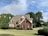 brown and white concrete house near green trees under blue sky during daytime