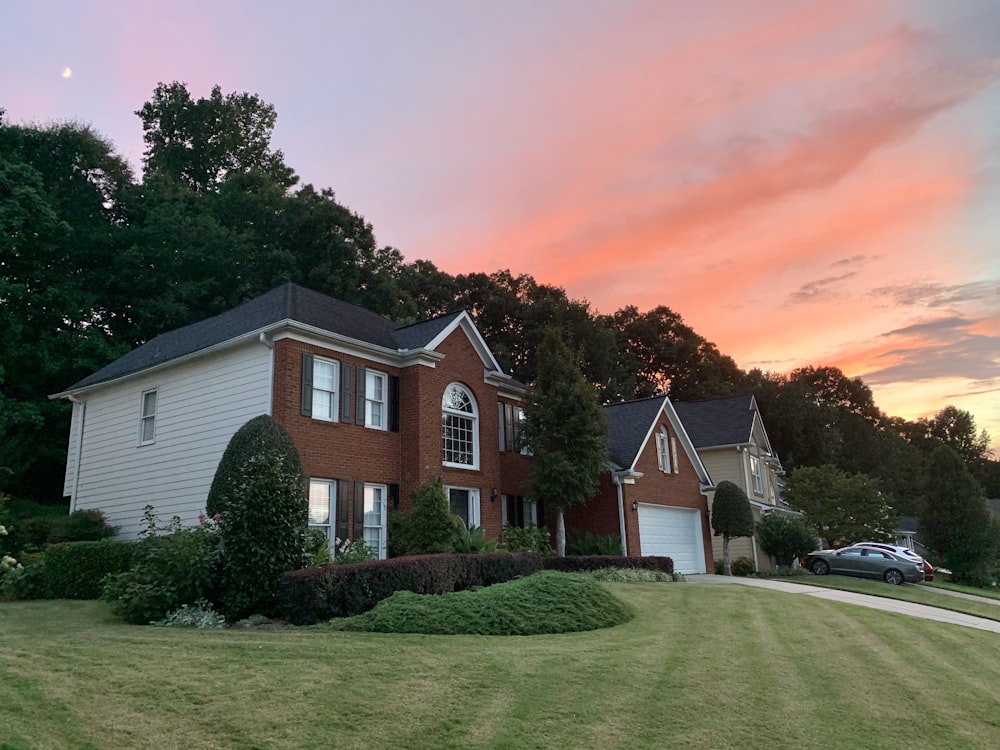 white and brown house near green grass field during daytime