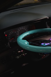 Close-up of a sleek car dashboard with illuminated gauges glowing softly against a black background.