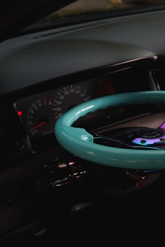 Close-up of a sleek car dashboard with illuminated gauges glowing softly against a black background.