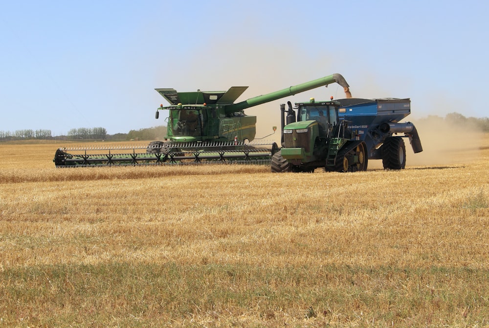 green and black heavy equipment on brown field during daytime