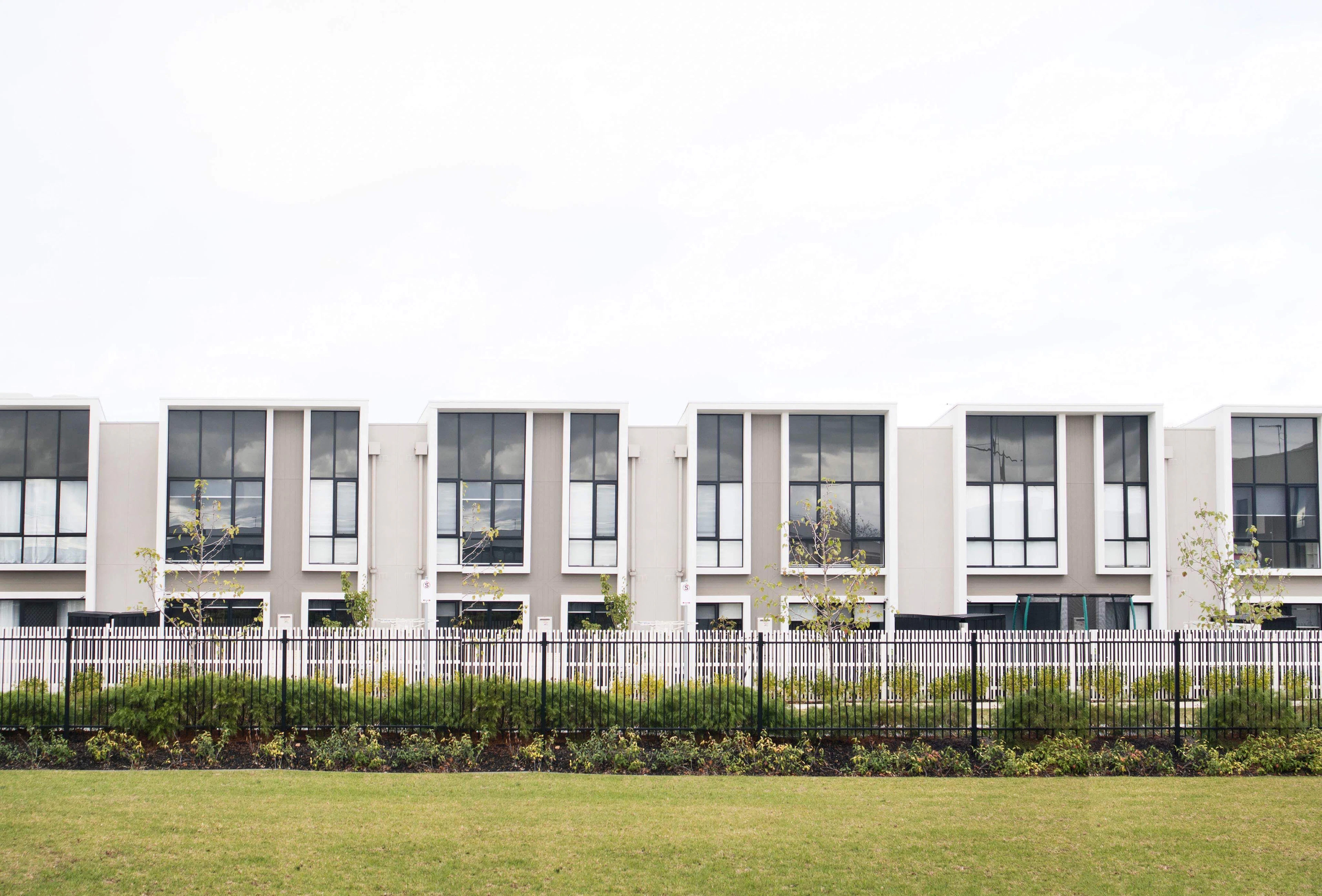 Row of modern white townhouses in a gated community