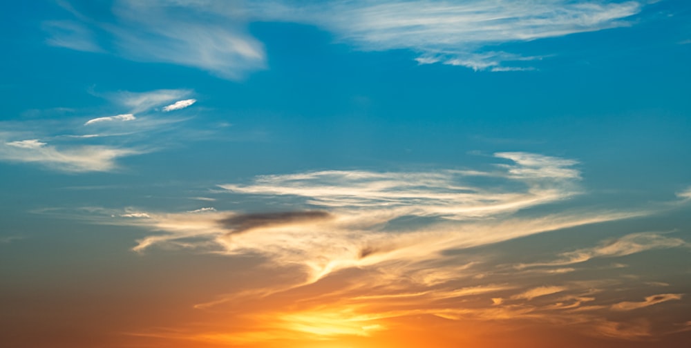 ciel nuageux bleu et orange au coucher du soleil