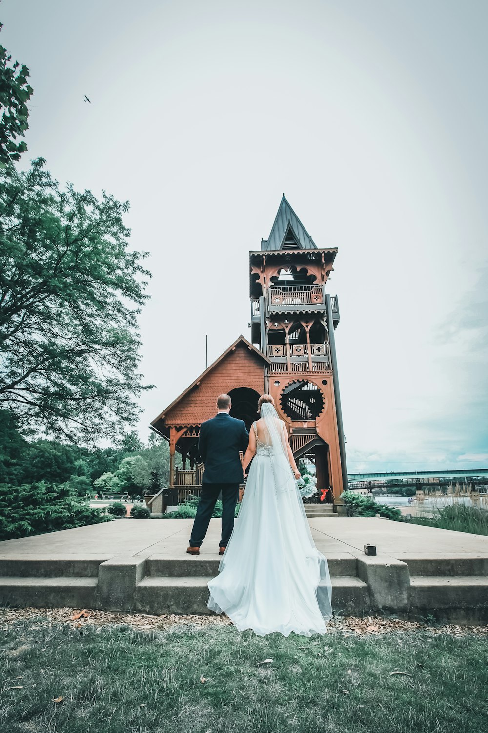 donna in abito da sposa bianco che cammina sul marciapiede durante il giorno