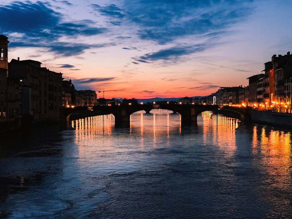 body of water between buildings during sunset