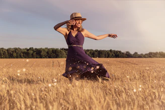 woman in brown sun hat standing on wheat field during daytime