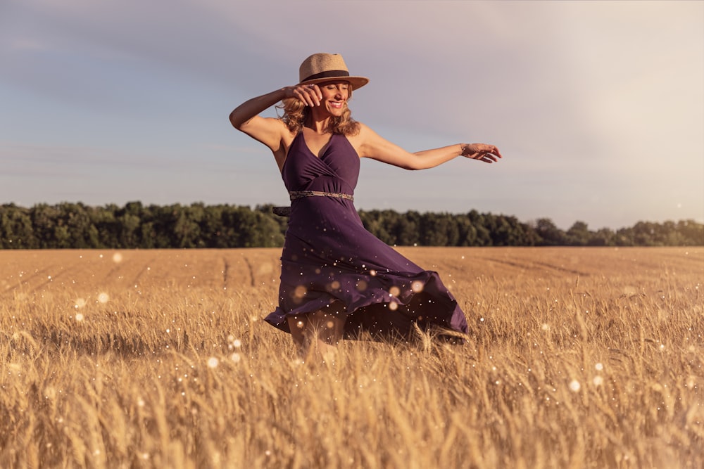 낮 동안 밀밭에 서 있는 갈색 태양 모자를 쓴 여자