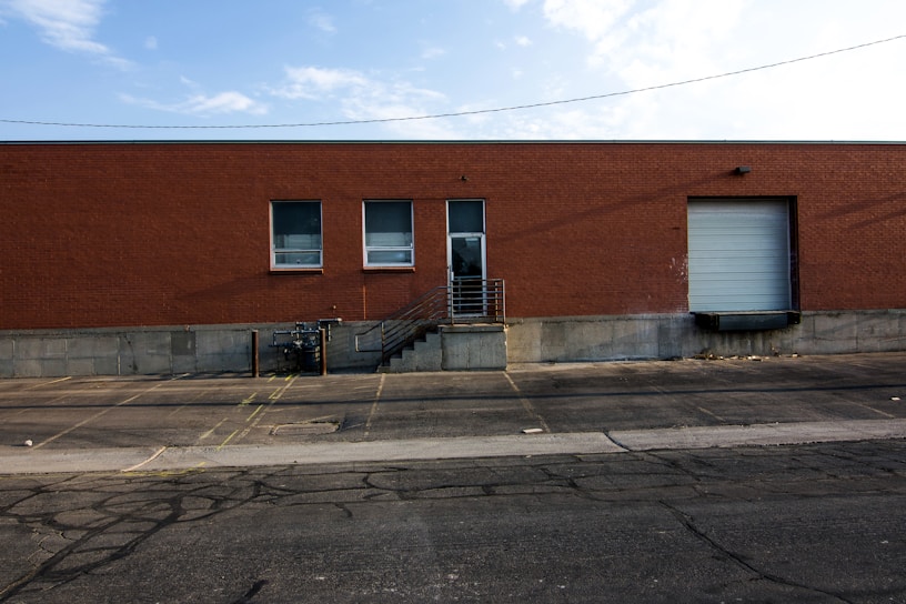 A modern industrial warehouse with large loading docks under a clear sky.