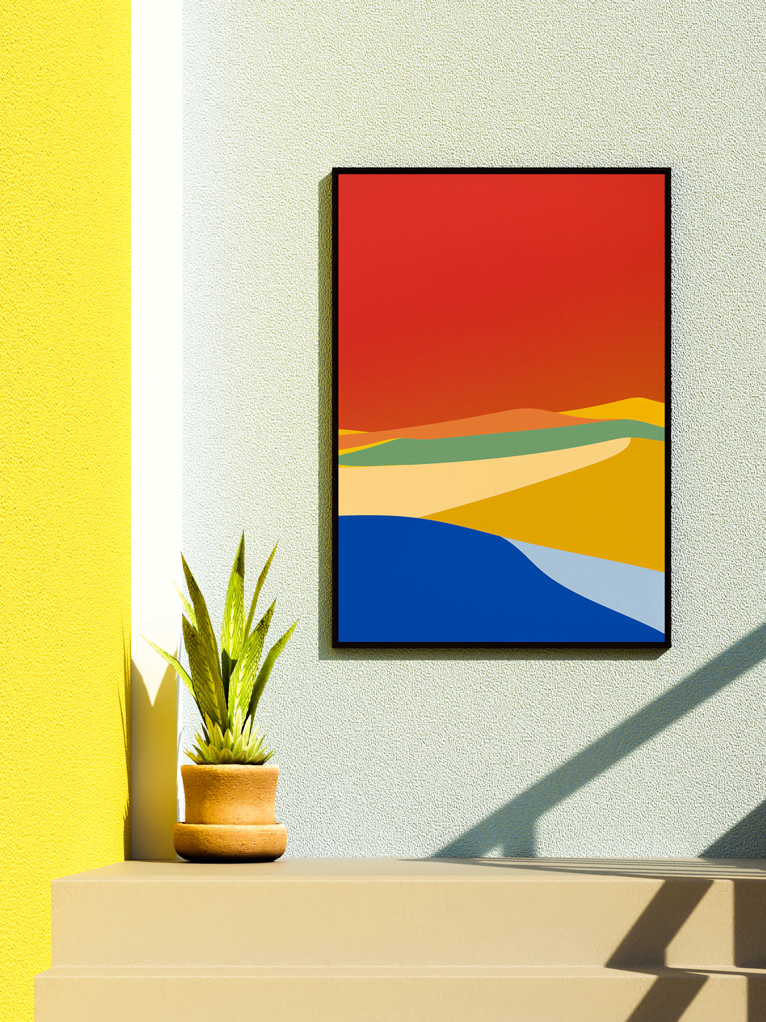 A colourful print in a thin black frame hanging on a yellow wall above a plant