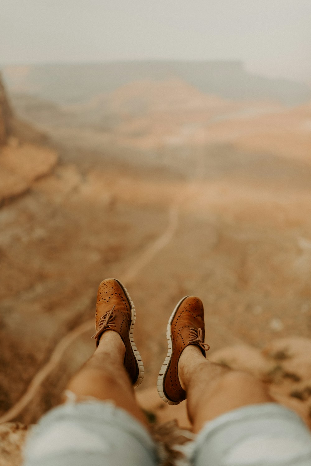 person in brown leather boots standing on brown sand during daytime