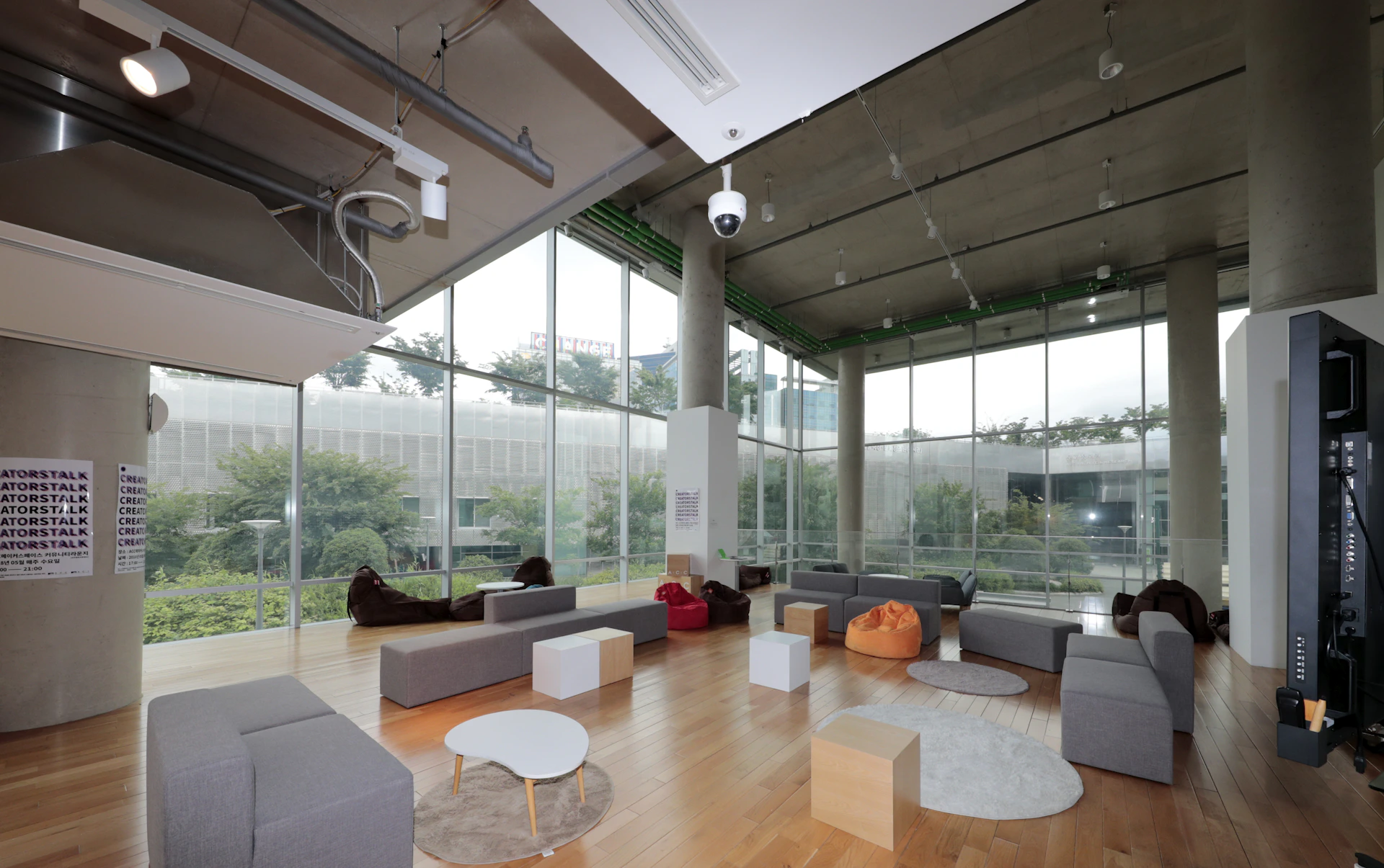 Panoramic image of the facility's open lounge area with comfortable seating and large windows overlooking greenery.